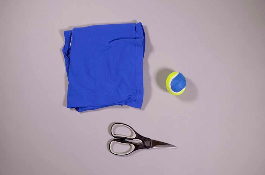 T-shirt, tennis ball and scissors on a table