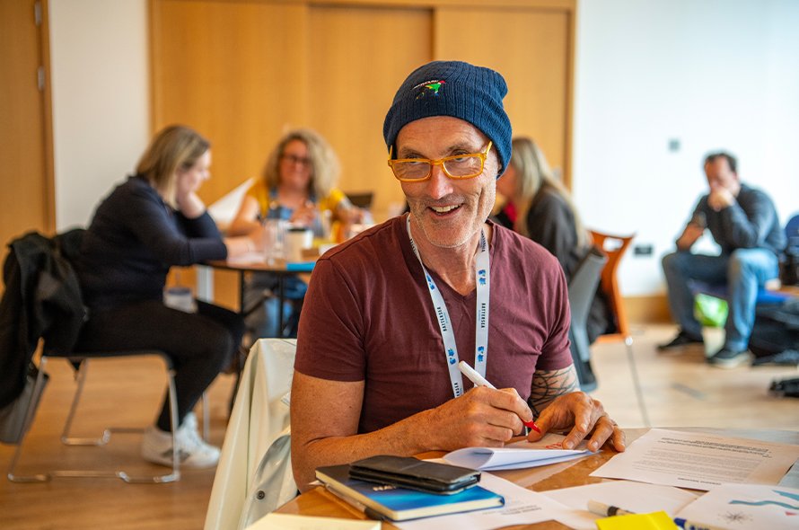 A person sitting at a table smiling