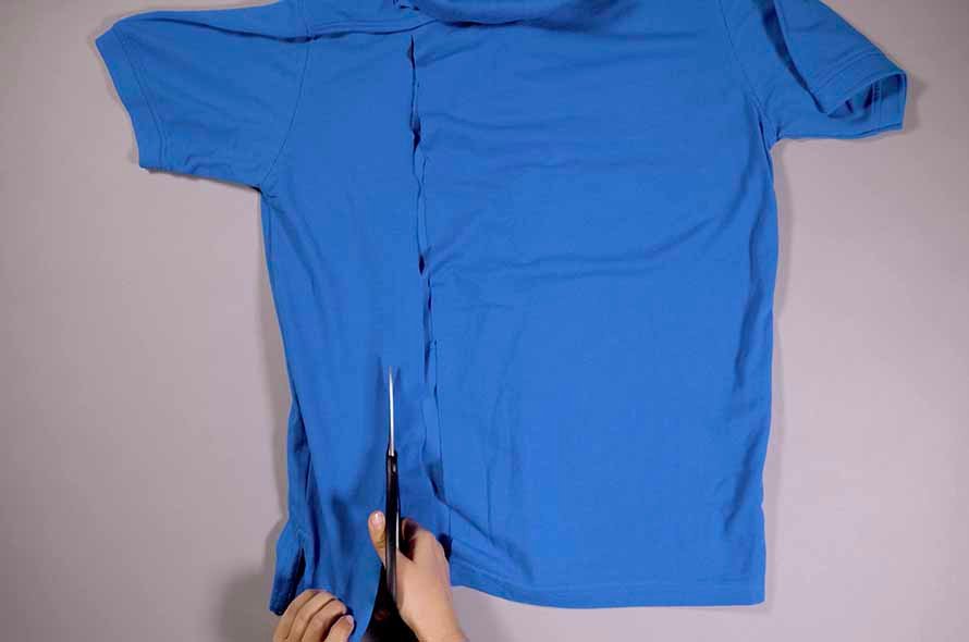A t-shirt being cut with a pair of scissors