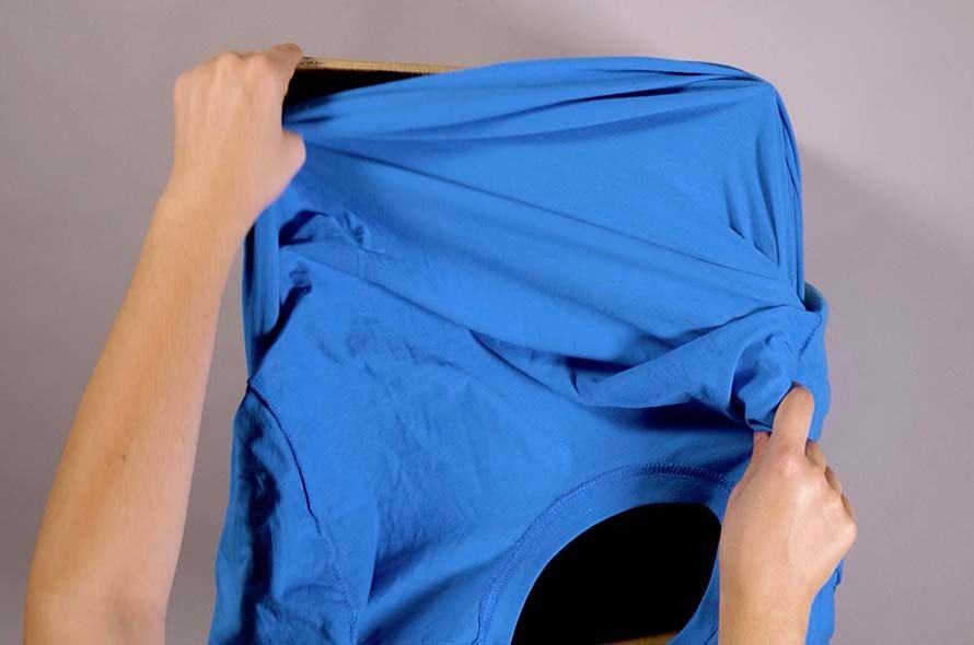 A t-shirt being adjusted around a cardboard box