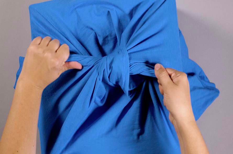 A t-shirt being tied around a cardboard box