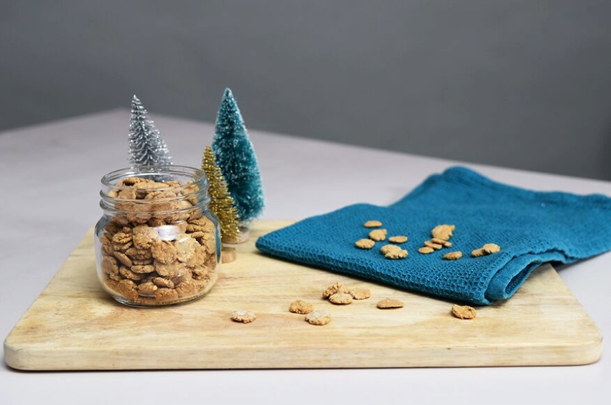 Christmas cat treats on a wooden chopping board with decorations