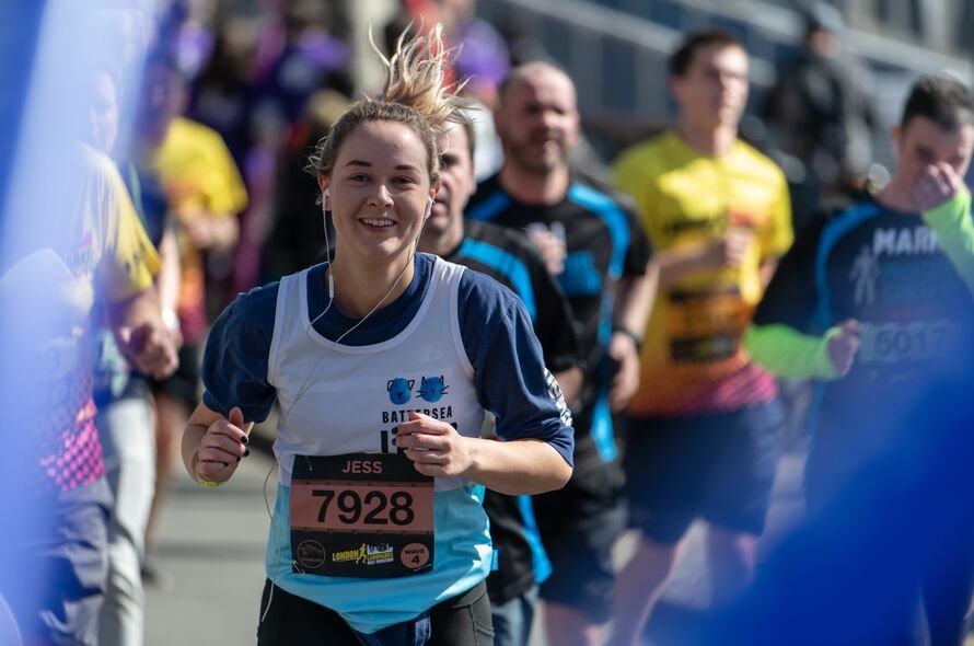 Fundraising running in an event for Battersea, wearing a Battersea running top